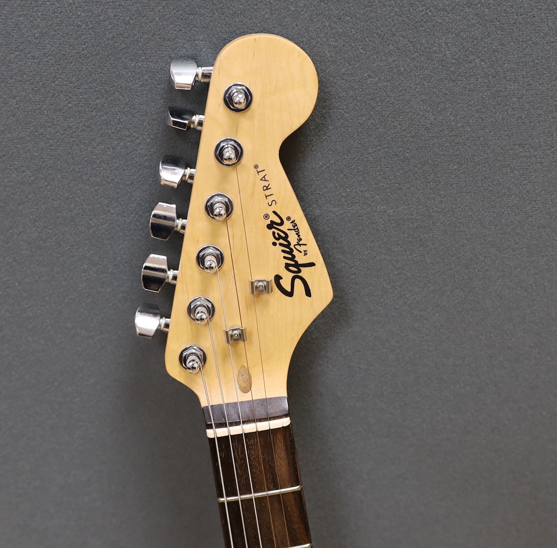 A Squier Strat by Fender Sunburst electric guitar made in China with rosewood neck, together with a small Squire SP-10 amp
